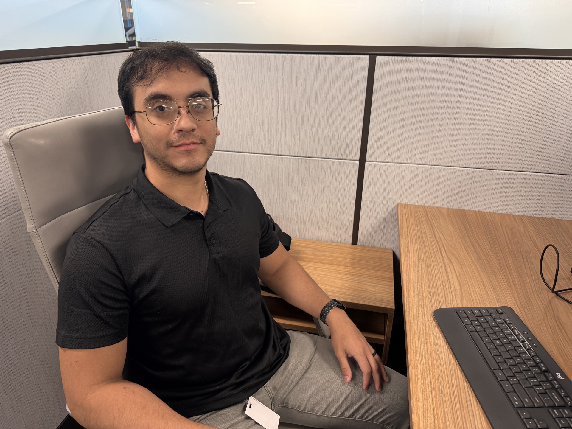 Man sitting at desk looking into camera.
